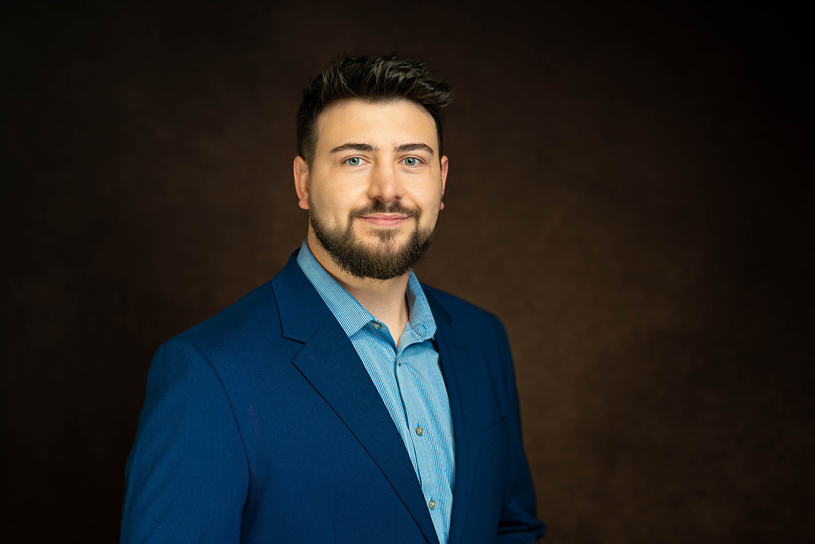 Academic Search executive headshot in navy blazer — studio portrait